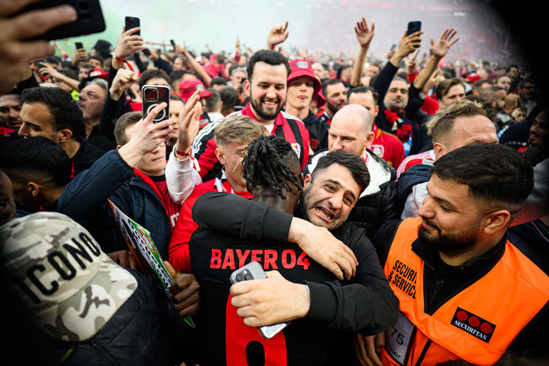Niềm vui của các cầu thủ và CĐV Leverkusen sau khi vô địch.
