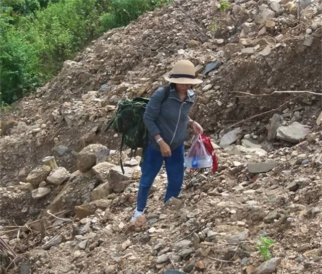 Vai mang ba lô, nữ giáo viên vượt qua những mái đồi trơ sỏi đá để đến trường sau ngày lũ
