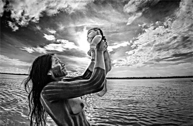 Người phụ nữ bộ lạc Kayapó tắm cho em bé ở sông Xingu, bang Mato Grosso.