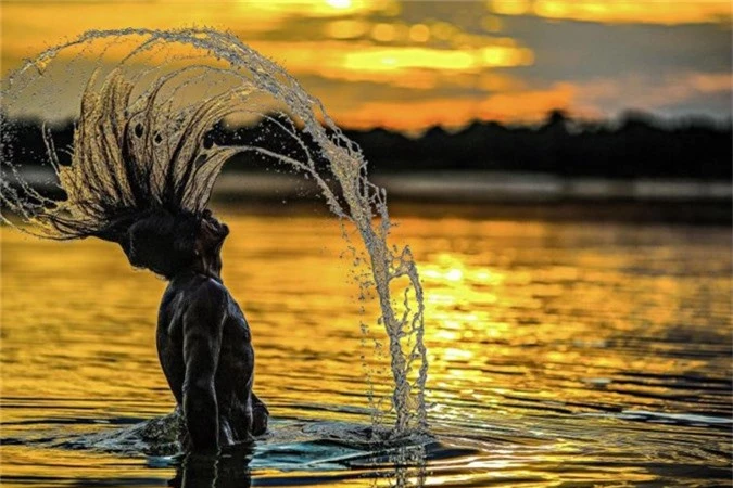 Người đàn ông bộ lạc Bejà Kayapó tắm trên sông Xingu River vào chiều hoàng hôn.