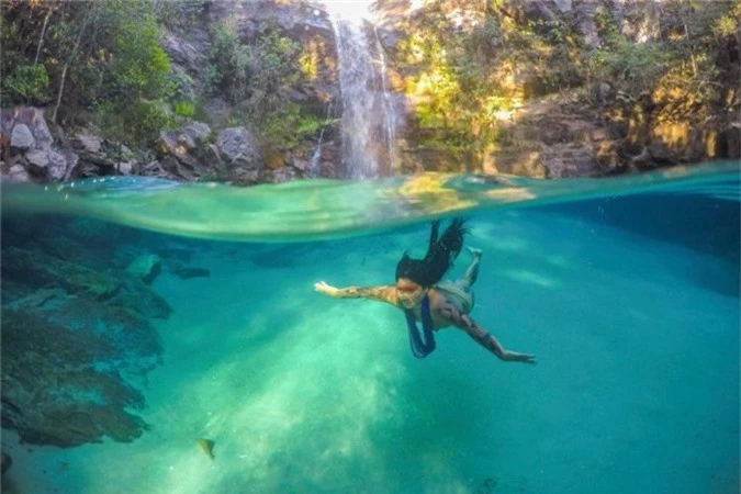 Một nữ thành viên bộ lạcAkuku Kamauyrá lặn dưới thácSanta Bárbara ở Chapada dos Veadeiros, Brazil.