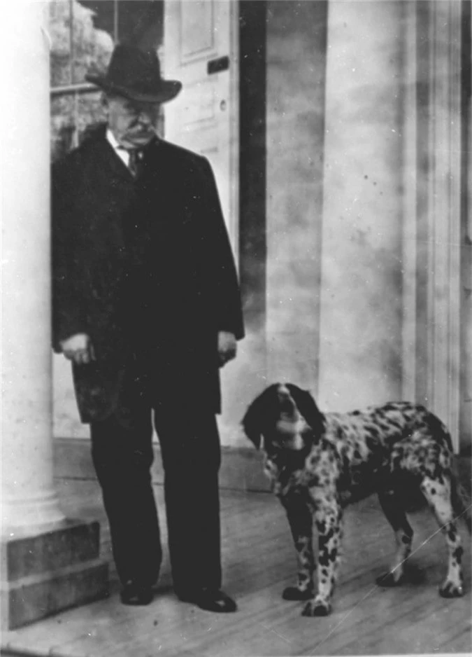 Tổng thống Grover Cleveland đứng cạnh cún cưng Cocker Spaniel, chú chó có bộ lông màu nâucùng đôi tai với chiều dài đến mức bất tiện.