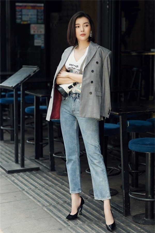 Cao Thái Hà kết hợp áo blazer với áo thun trắng, quần Jean ống rộng giúp cô thoải mái xuống phố. Túi Chanel Gabrielle và đôi giày YSL là hai món hàng hiệu hoàn thiệnset đồ của nữ diễn viên.