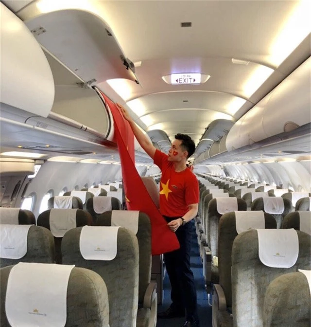 Tiếp viên Nguyễn Hữu Trung chỉnh trang lá cờ Tổ quốc trên máy bay chào đón các vận động viên Việt Nam