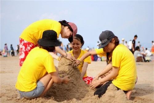 Nhóm bạn trẻ đắp cát trên bãi biển. Ảnh: Nguyễn Khoa