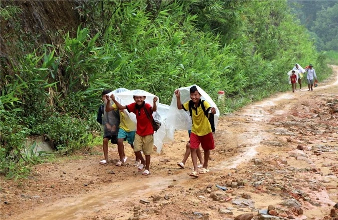 Học sinh đội mưa, vượt đường trơn để đến trường dự Lễ khai giảng năm học mới. (Ảnh: Việt Hoàng/TTXVN)