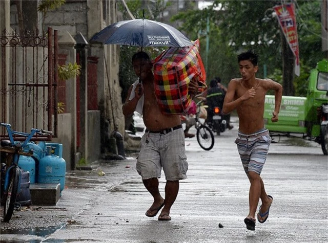 Tổng thống Philippines Rodrigo Duterte hôm nay đã có cuộc họp với trung tâm cứu trợ thảm họa để bàn phương án ứng phó với bão Mangkhut. Trong ảnh: Người dân ở Cagayan mang đồ đạc đi sơ tán. (Ảnh: AFP)