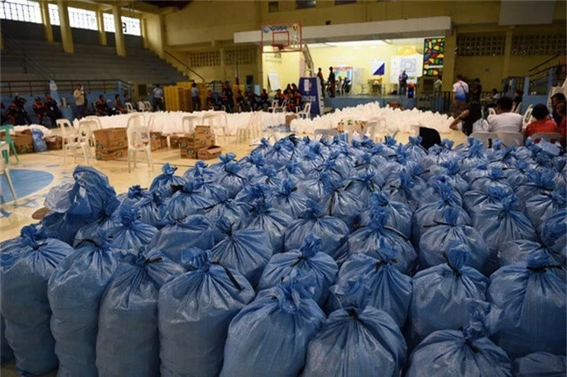 Ít nhất 135 chuyến bay đã bị hủy trên cả nước Philippines. Lực lượng tuần duyên Philippines cho biết hơn 4.000 người vẫn đang bị mắc kẹt trên các đảo vì phà không thể di chuyển do điều kiện thời tiết xấu. Trong ảnh: Các bao chứa lương thực được chuẩn bị cho người dân ứng phó với bão tại Philippines. (Ảnh: AFP)