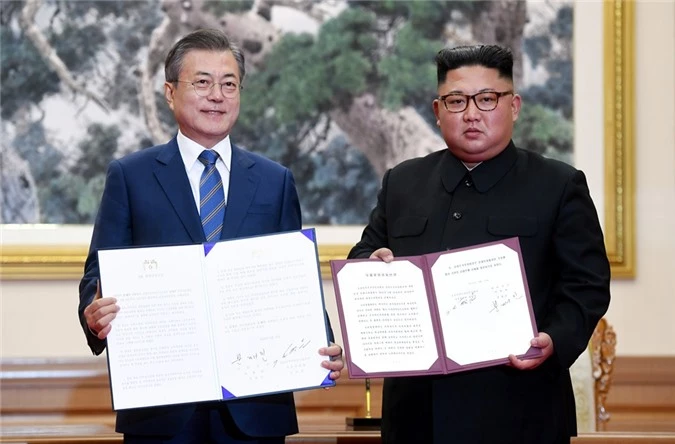 Nhà lãnh đạo Kim Jong-un và Tổng thống Moon Jae-in trưng tuyên bố chung vừa ký kết. (Ảnh: Reuters)