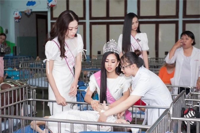 Hoa hậu Trần Tiểu Vy và các người đẹp khác xúc động lắng nghe câu chuyện của các em nhỏ từ nhân viên trung tâm.