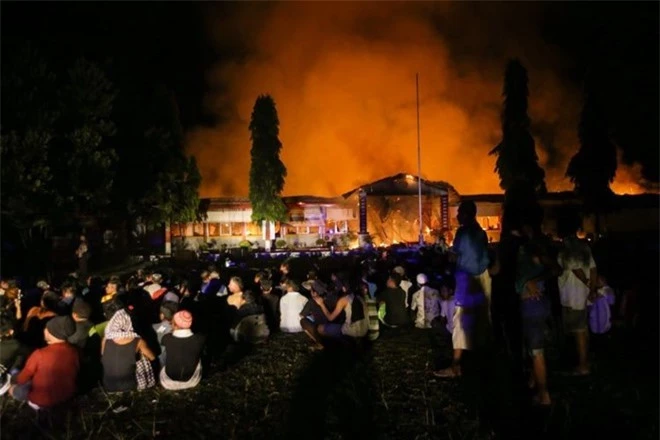 Các tù nhân tụ tập ngoài sân trong lúc ngọn lửa bùng lên tại nhà tù Donggala sau trận bạo loạn hôm 29/9/2018. Ảnh: Kompas.com)