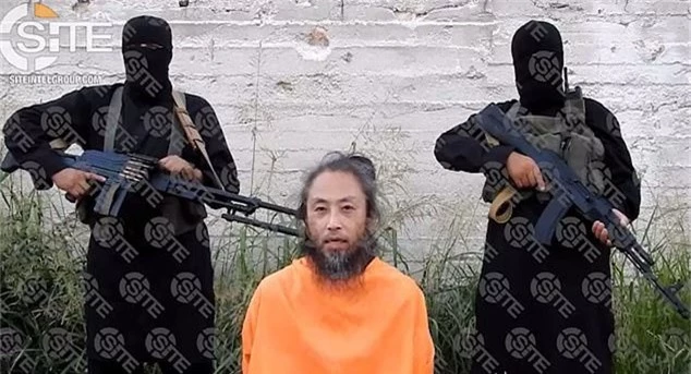 Ông Yasuda bị những kẻ bắt cóc dí súng vào đầu trong bức ảnh công bố hồi tháng 7 năm nay (Ảnh: AFP)