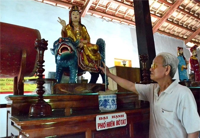 Ông Huỳnh Văn Bảy và pho tượng gỗ Phổ Hiền thờ trong chùa, được đánh giá
trăm năm tuổi. Ảnh: Lục Tùng