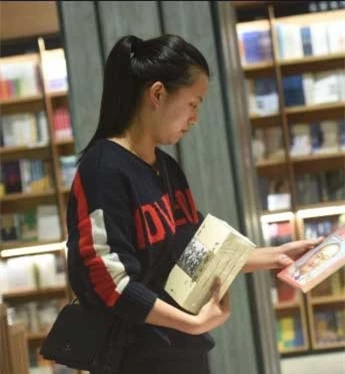 Một bạn đọc tham khảo mua sách của Kim Dung. Ảnh: GETTY/AFP