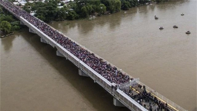 Đoàn di dân tới Mỹ chen chúc qua một cây cầu. (Ảnh: AFP)