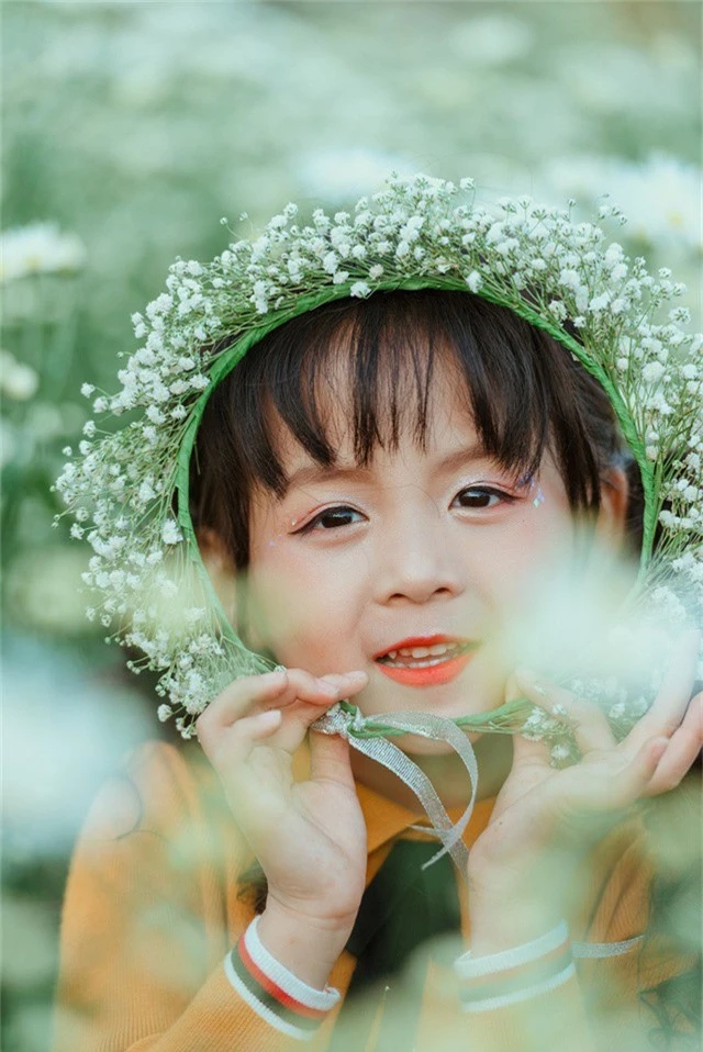 Trong bộ ảnh kỷ niệm 5 tuổi của mình, Ali mặc bộ váy màu vàng, mũ len vàng tự tin tạo dáng bên hoa cúc họa mi đầu mùa.