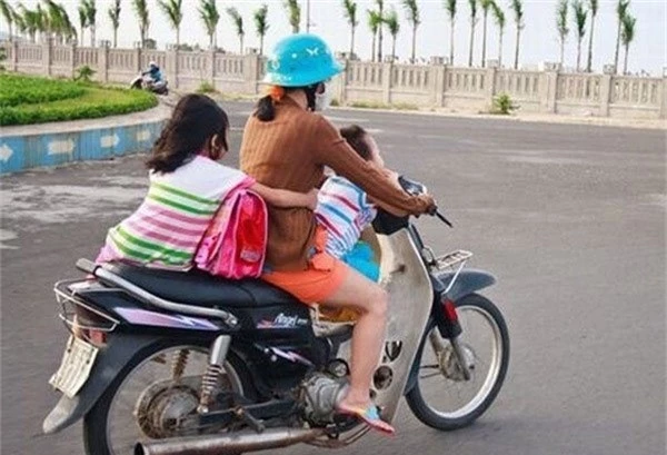 Bà mẹ 1 tay lái xe máy, 1 tay ôm con bú trên đường