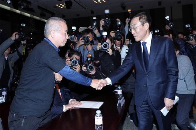  Giám đốc điều hành Samsung Electronics Kim Ki-nam (phải) bắt tay với ông Hwang Sang-gi, người sáng lập nhóm Sharps, tại sự kiện ký thỏa thuận đền bù ở Seoul ngày 23-11. Ảnh: REUTERS 