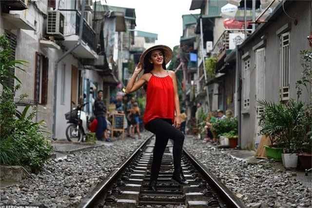 Một cô gái ngoại quốc đội nón lá, duyên dáng tạo hình trên đường ray