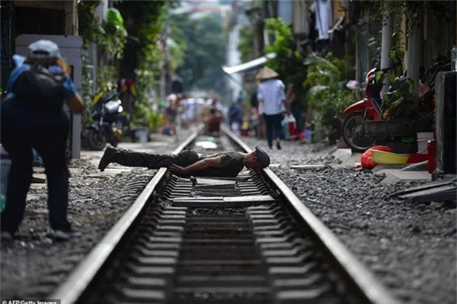 Một nam thanh niên tạo hình tư thế lạ để chụp ảnh trên đường ray