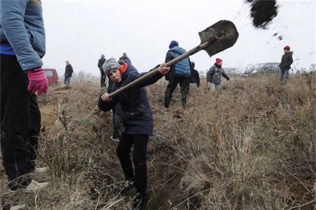  Một thiếu niên cùng các tình nguyện viên đào hào tại thành phố Mariupol (Ảnh: AFP) 