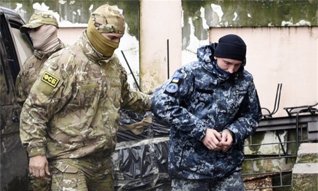  Sĩ quan tình báo Nga áp giải một thủy thủ Ukraine bị Nga bắt giữ tới tòa án ở Crimea hôm 27/11 (Ảnh: AP) 