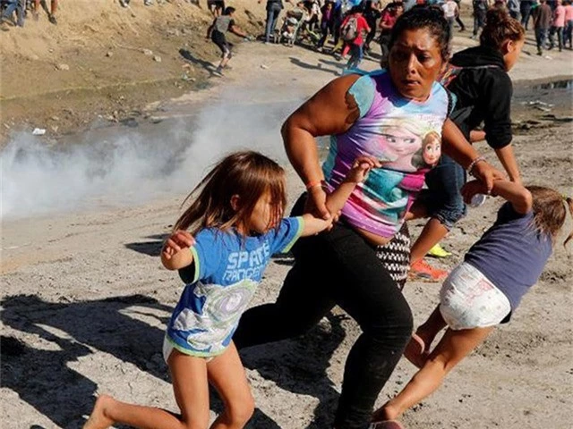  Người mẹ Maria Mesa và hai con nhỏ chạy tránh hơi cay do lực lượng biên phòng Mỹ bắn ra ở khu vực biên giới TP Tijuana (Mexico) và TP San Diego (Mỹ). Ảnh: CNN 