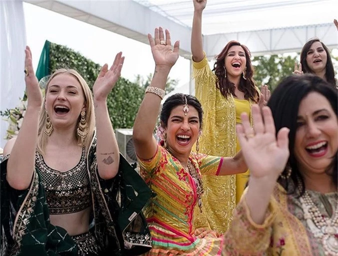 Cặp đôi cùng các khách mời nhảy múa và ca hát trong bữa tiệc sau nghi lễ Mehndi. Priyanka Chopra đã chuẩn bị sẵn váy áo Ấn Độ cho khách khứa mặc trong trong sự kiện này. Nữ diễn viên Game of Throne Sophie Turner (bên trái) khiêu vũ tưng bừng bên cô dâu. Sophie là bạn thân đồng thời là chị dâu của Priyanka.