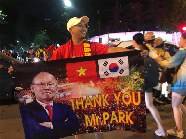  Một cổ động viên đã chuẩn bị banrol có hình ảnh của huấn luyện viên Park Hang Seo giương cao ngoài phố để mừng chiến thắng 