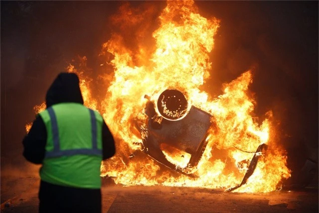  Người biểu tình đốt xe phản đối chính sách tăng thuế của chính phủ tại Paris. (Ảnh: Reuters) 