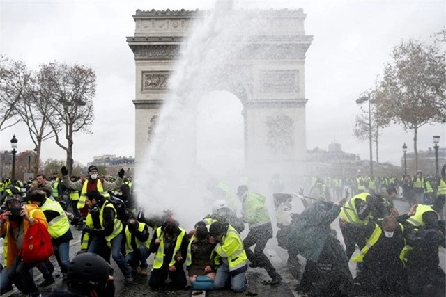  Cảnh sát phun nước vào những người biểu tình Áo vàng tại Paris. (Ảnh: Reuters) 