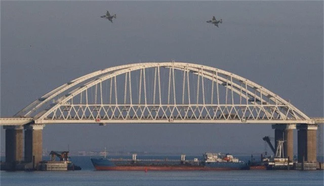  Tàu chở hàng Nga chặn dưới cầu Kerch trong khi máy bay hoạt động trên không trong vụ đụng độ với các tàu chiến Ukraine. (Ảnh: RT) 