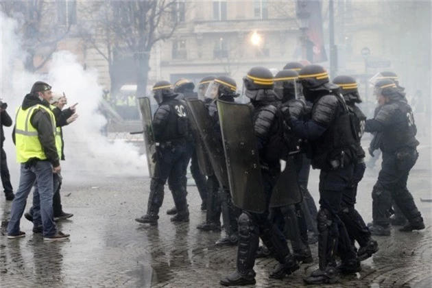  Cảnh sát chống bạo động Pháp đối mặt với người biểu tình Áo vàng tại Paris. (Ảnh: AFP) 