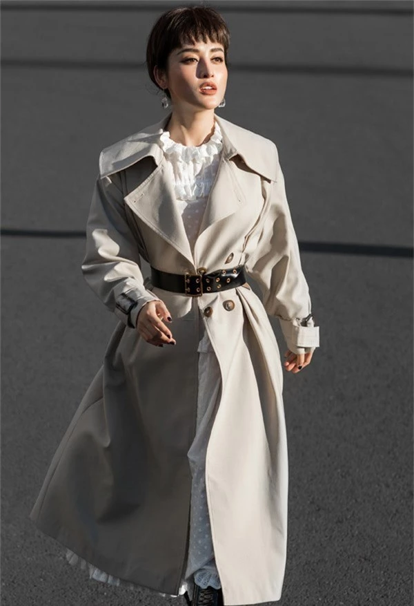 Váy trắng cổ điển phối hợp cùng áo khoác oversize tạo cho Á hậu vẻ ấn tượng. 