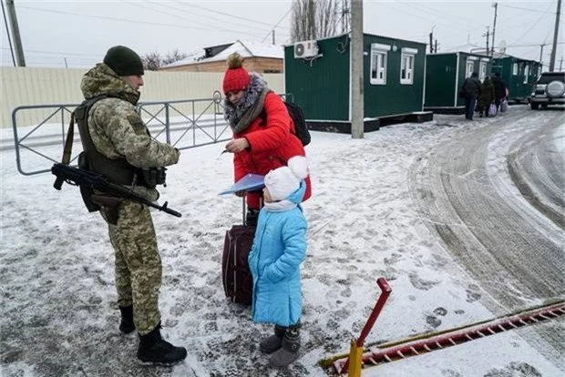  Một phụ nữ trình giấy tờ cho lính biên phòng Ukraine kiểm tra trước khi qua biên giới. Trước đây, người dân hai nước có thể tự do qua lại khu vực này. (Ảnh: AP) 