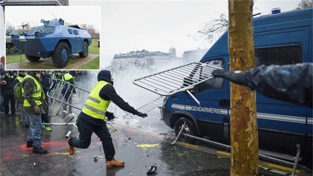  Một người biểu tình Áo vàng ném thanh chắn hàng rào trong cuộc biểu tình tại Paris. (Ảnh: Reuters) 