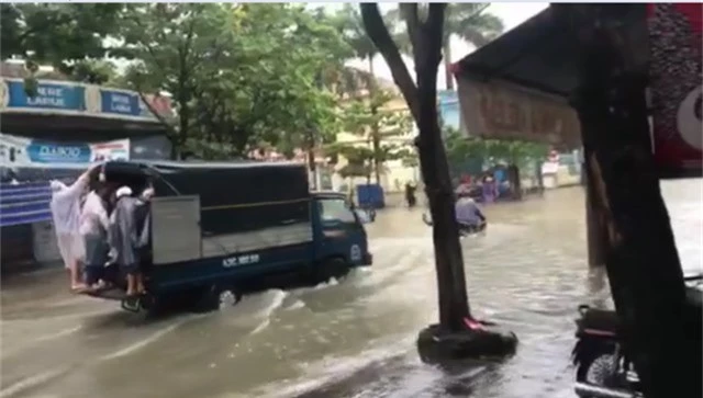 
Xe tải giúp chở người và xe qua đoạn đường ngập nước.
