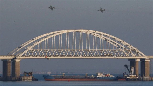  Tàu chở hàng Nga chặn lối ra vào dưới cầu tại eo biển Kerch trong khi máy bay hoạt động trên không trong vụ đụng độ với các tàu Ukraine hôm 25/11. (Ảnh: TASS) 