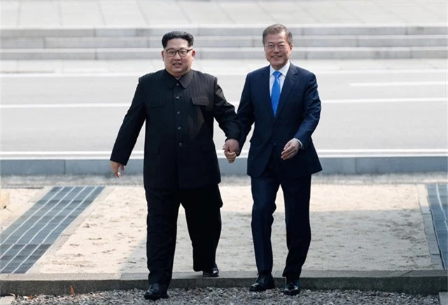 
Nhà lãnh đạo Triều Tiên Kim Jong Un và Tổng thống Hàn Quốc Moon Jae In dắt tay nhau tại Bàn Môn Điếm ở biên giới liên Triều tháng 4/2018 (Ảnh: Reuters)
