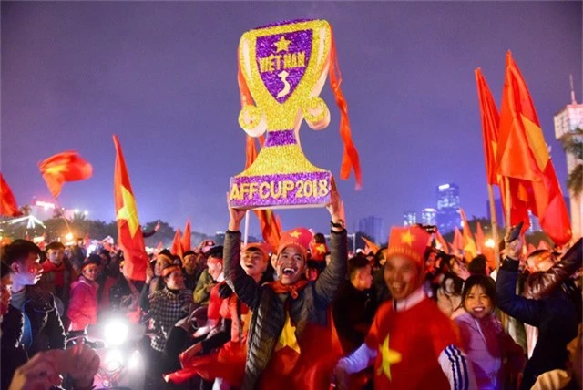 Người hâm mộ nâng cao chiếc cúp tự chế ăn mừng đội tuyển Việt Nam vô địch.