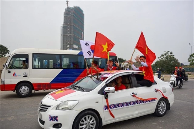 Một số cổ động viên di chuyển bằng ô tô tay cầm cờ đỏ sao vàng và lá cờ quốc kỳ Hàn Quốc quê hương của HLV Park Hang Seo.