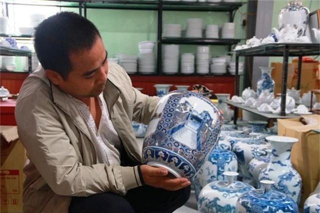 Nghệ nhân Phạm Văn Vang bên sản phẩm gốm do chính tay mình làm ra.