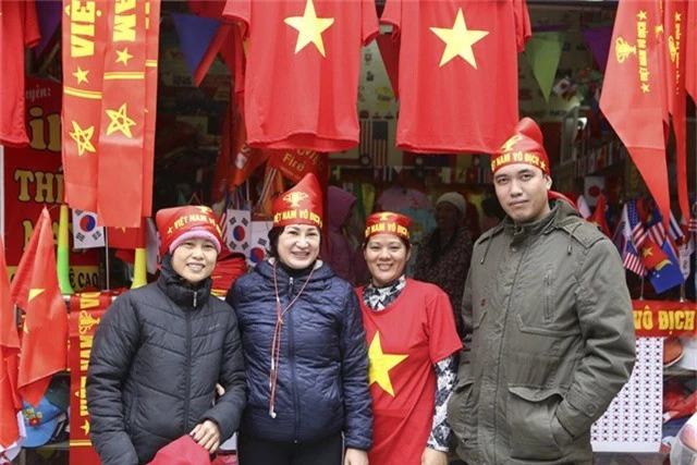  Người bán hàng cũng hào hứng đội những chiếc khăn đỏ trên đầu với dòng chữ Việt Nam vô địch. 