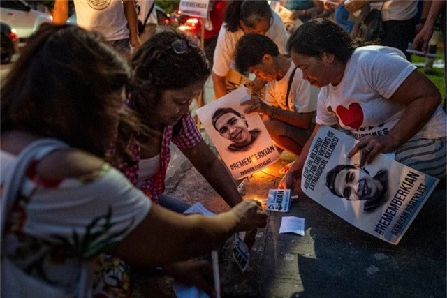 Những người biểu tình thắp nến tưởng niệm một năm sự ra đi của Kian delos Santos - học sinh 17 tuổi bị giết nhầm trong cuộc chiến chống ma túy tại Philippines năm 2017 (Ảnh: New York Times)