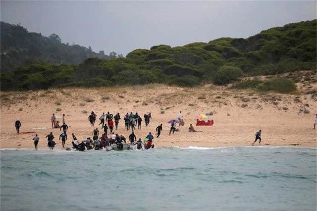  Người tị nạn ồ ạt chạy từ xuồng lên bờ tại bãi biển ở phía nam Tây Ban Nha sau khi vượt qua eo biển Gibraltar để đến “miền đất hứa” hồi tháng 7. 