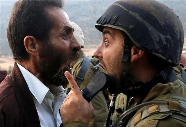  Một người đàn ông Palestine tranh cãi với binh sĩ Israel trong cuộc đụng độ liên quan tới việc Israel ra lệnh đóng cửa một trường học của Palestine gần Nablus, Bờ Tây hôm 15/10. 