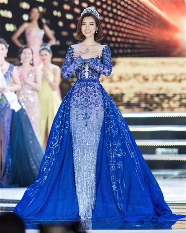 Hoa hậu Đỗ Mỹ Linh nổi bật trên sân khấu với thiết kế váy đính kết công phu của Lê Thanh Hòa. Từng chi tiết hoa nổi, tua rua đều được thực hiện thủ công để mang đến đường nét sắc xảo cho trang phục. Ngoài ra nhà thiết kế còn tạo khối ấn tượng cho phần tà váy. 