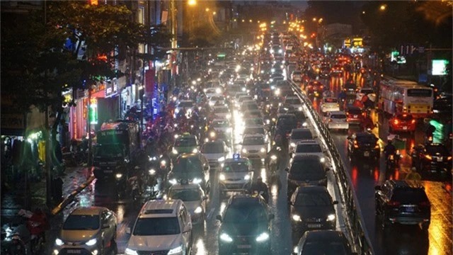 Người dân đổ ra bến xe về nghỉ Tết, đường phố Hà Nội ùn tắc trong mưa - Ảnh 1.
