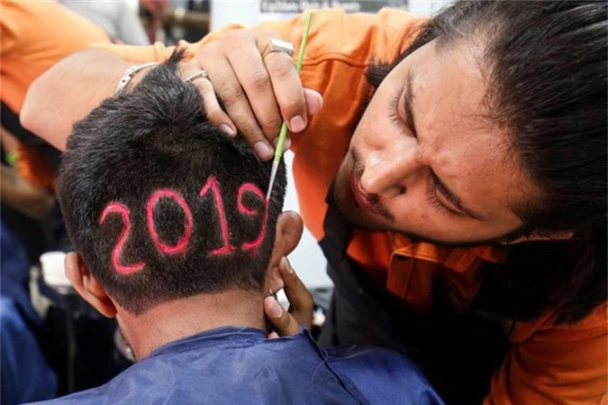 Ahmedabad, India A man applies color to a haircut with the number 2019, depicted to welcome the new year at a barbershop in Ahmedabad, India, on Dec. 30.