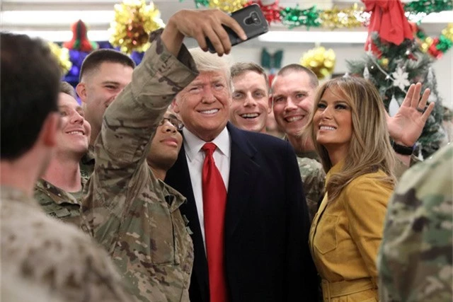 Tổng thống Trump và phu nhân chụp ảnh với các binh sĩ tại căn cứ Al Asad ở Iraq hôm 26/12. (Ảnh: Reuters)